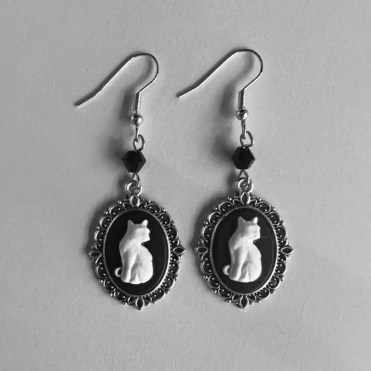 Vintageinspirerade örhängen med vitt kattmotiv